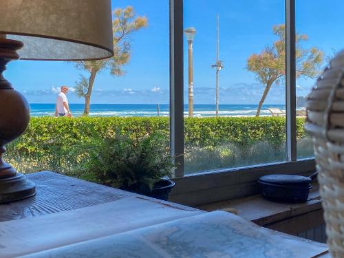 a bedroom with a view of the beach from a window at Hotel Arimune in Bakio