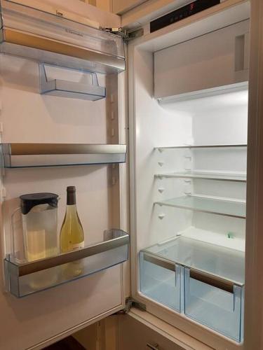 an open refrigerator with a bottle of wine in it at V&V CENTRE Neuchatel in Neuchâtel