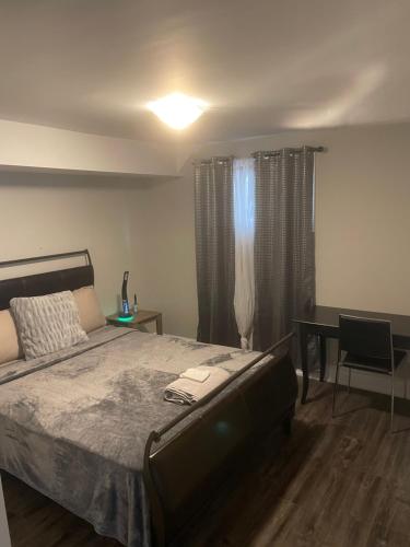 a bedroom with a bed and a table and a desk at Stunning & cozy freshly renovated 2 bedroom basement unit in Kitchener