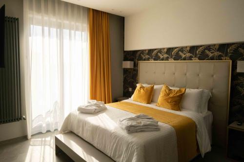 a bedroom with a large bed with yellow pillows at Divina Charme in Mascalucia