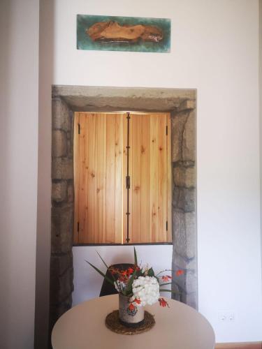 a table in front of a door with flowers on it at Casa da Boa Vista in Algarvia
