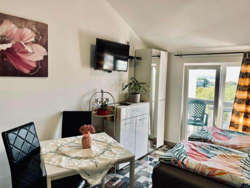 a small living room with a table and a bed at Apartmani Tamara in Tivat