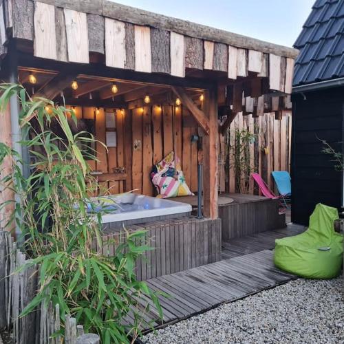 a wooden deck with a hot tub on it at wellness chalet met jacuzzi, sauna, omheinde tuin, in Sint Annaland