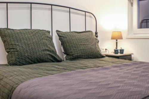 a bed with two pillows on top of it at wellness chalet met jacuzzi, sauna, omheinde tuin, in Sint Annaland
