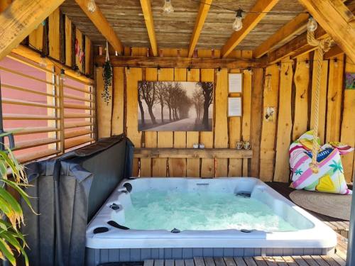 a jacuzzi tub in a wooden house at wellness chalet met jacuzzi, sauna, omheinde tuin, in Sint Annaland