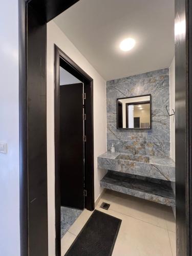 a bathroom with a black door and a mirror at Follow Sea Villa in Sowayma
