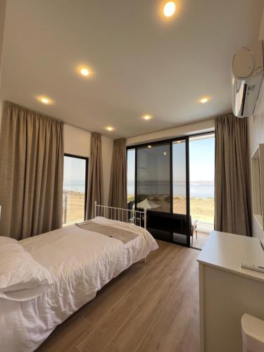 a bedroom with a bed and a view of the beach at Follow Sea Villa in Sowayma