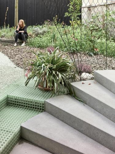 a woman sitting on the steps of a garden at ENTZÜCKENDE KLEINE WOHNUNG in Linz