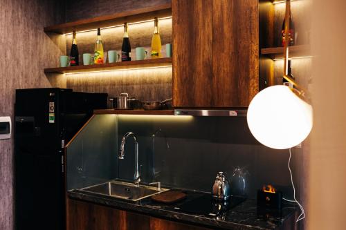 a kitchen with a sink and a refrigerator at Apastar Luxury - Vinhomes Smart City in Hanoi