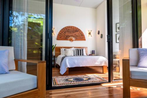 a bedroom with a bed and a sliding glass door at La Prometida in Puerto Viejo