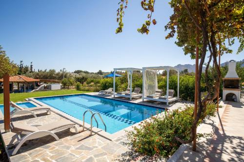 a swimming pool with lounge chairs and a resort at 12 Islands Villas in Kolymbia
