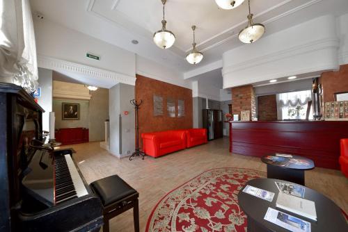 a living room with a red couch and a red piano at Rachmaninoff Hotel in Velikiy Novgorod