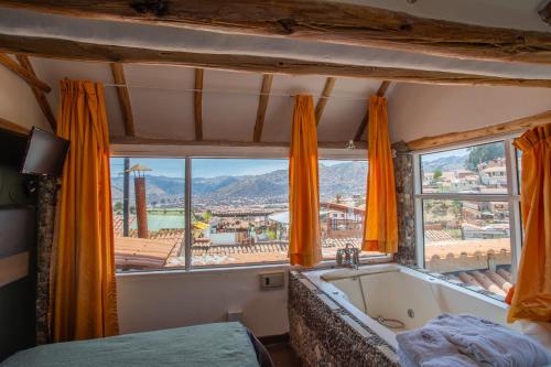 a bedroom with a tub and a large window at Cities of the World - Apartments Cusco in Cusco