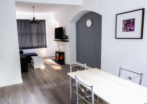 a living room with a table and a fireplace at Cozyhouses in Hull