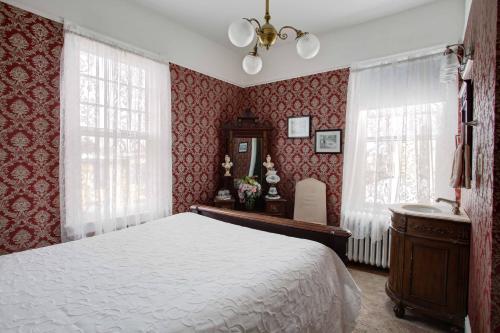 a bedroom with red walls and a bed and a sink at Wilbraham Mansion in Cape May