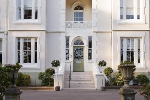 a white house with a green door and stairs at The Green House in Bournemouth