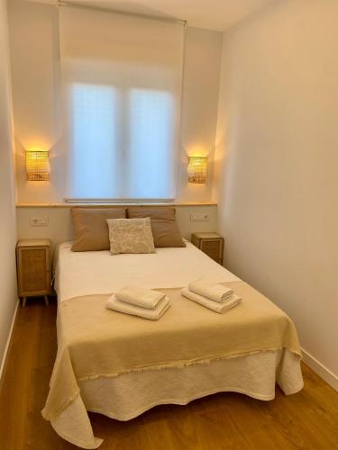 a bedroom with a bed with two towels on it at La Espiga de Segovia in La Lastrilla