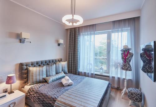 um quarto com uma cama e uma grande janela em Playa Baltis Cristina em Międzyzdroje