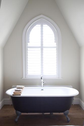 a bath tub in a room with a window at The Green House in Bournemouth