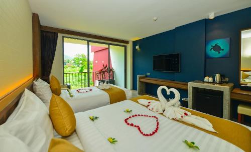 a hotel room with two beds with decorations on them at Le Resort and Villas in Rawai Beach