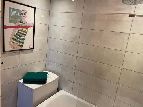 łazienka z toaletą z plakatem na ścianie w obiekcie Apartament Karlikowska z widokiem na morze w mieście Sopot