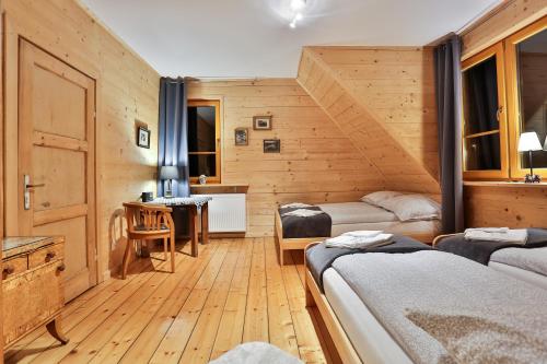 Pokój z 2 łóżkami i biurkiem w pokoju w obiekcie Willa Dalia w Rabce