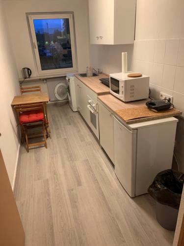 uma cozinha com armários brancos e um micro-ondas no balcão em BK Meiderich em Duisburg