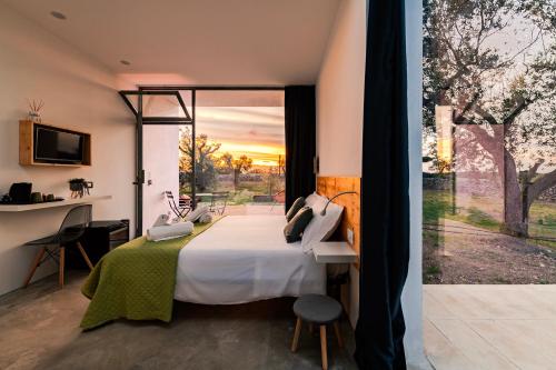 a bedroom with a bed and a large window at Terecate Experimental Relais in Melendugno
