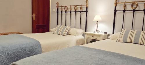 ein Schlafzimmer mit 2 Betten und einem Tisch mit einer Lampe in der Unterkunft Sierra de Aracena Cala Huelva in Cala
