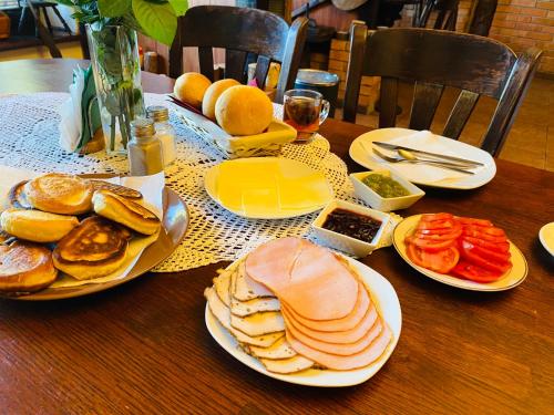 a wooden table with plates of food on it at Karczma Pod Jesionem in Brdów