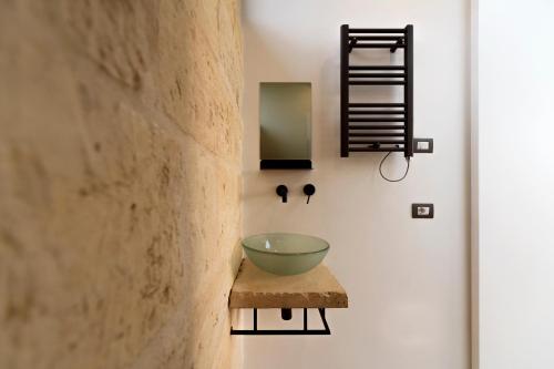 a bathroom with a green bowl on a stool at Terecate Experimental Relais in Melendugno