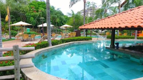 uma piscina num resort com mesas e cadeiras em Rio Quente Luppi Hotel em Rio Quente