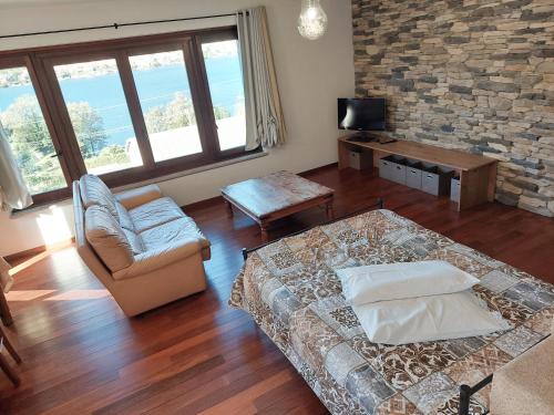 オメーニャにあるLuci dal Lagoのリビングルーム(ベッド1台、ソファ、テレビ付)