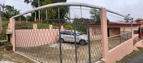 a gate with a car parked in a house at Casa entre la naturaleza in San Marcos