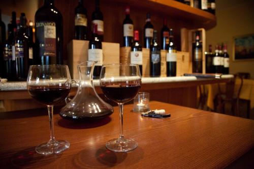 two glasses of wine sitting on a table with wine bottles at Hotel Venezia in Marina di Pietrasanta
