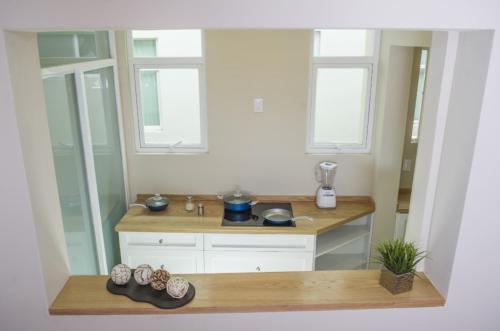 cocina con encimera y 2 ventanas en Casa Donceles, Complejo de Apt 1, 2 & 3 rec, Favorita para las Familias, Llegada Temprana Gratis! sujeto a disponibilidad, en Ciudad de México