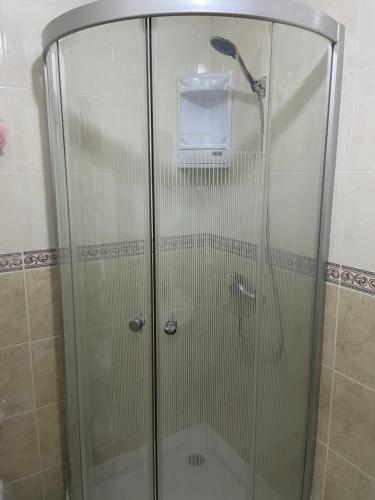 a shower with a glass door in a bathroom at Joli appartement balnéaire avec piscine in Tangier