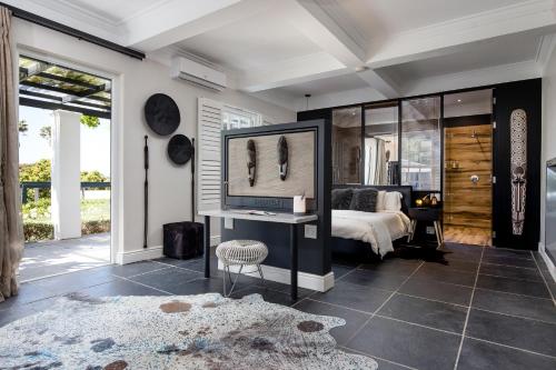a bedroom with a bed and a table and a mirror at 14 on Klein Constantia in Cape Town