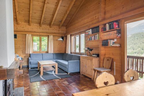 a living room with a blue couch in a cabin at Trimka in Fiesch