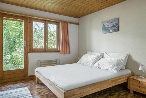 um quarto com uma cama e uma janela em Trimka em Fiesch