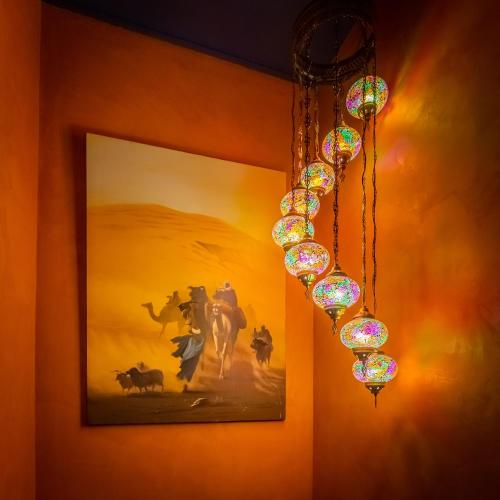 a chandelier hanging from a wall with a picture at Mille et une Nuits - La Vénus de Lisbonne in Calhandriz