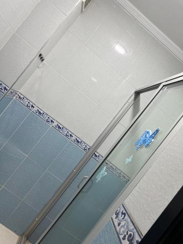 Una ventana de cristal en un baño con una pegatina azul. en Appartement Tanger, en Tánger