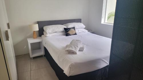 a bedroom with a bed with white sheets and pillows at Mooloolaba Beach Beachwalk in Mooloolaba