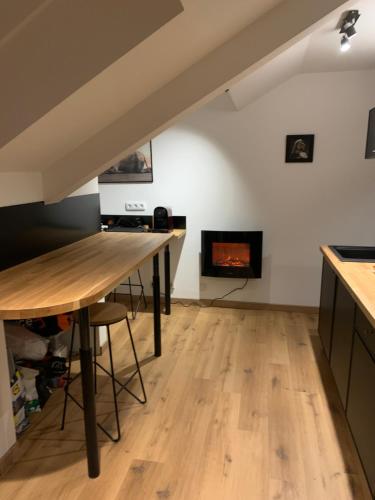 a kitchen with a wooden table and a fireplace at studio moderne in Barcelonnette