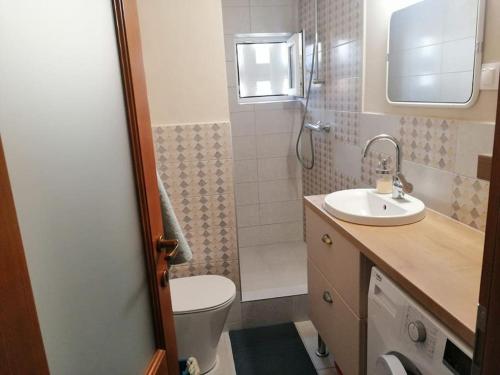 a small bathroom with a toilet and a sink at Delightful - Színes és pihentető in Odorheiu Secuiesc