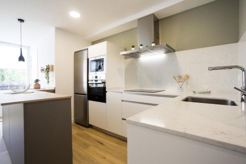 eine Küche mit weißen Arbeitsflächen und einem Waschbecken in der Unterkunft OLABIDE 2 by Smiling Rentals in Hondarribia
