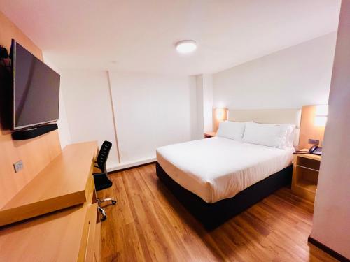 een hotelkamer met een bed en een flatscreen-tv bij OQ STANDARD HOTEL - Airport in Arequipa