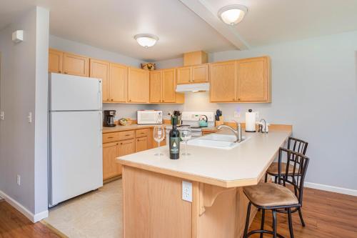 a kitchen with wooden cabinets and a white refrigerator at Alpine Escape in Leavenworth