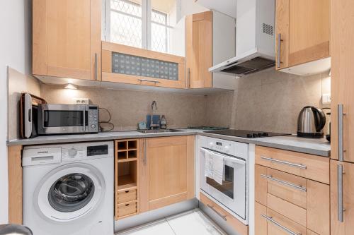 une cuisine avec un lave-linge et un micro-ondes dans l'établissement Wonderful and bright apartment close to everything, à Nice