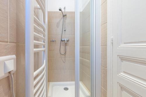 une douche avec une porte vitrée dans une salle de bain dans l'établissement Wonderful and bright apartment close to everything, à Nice